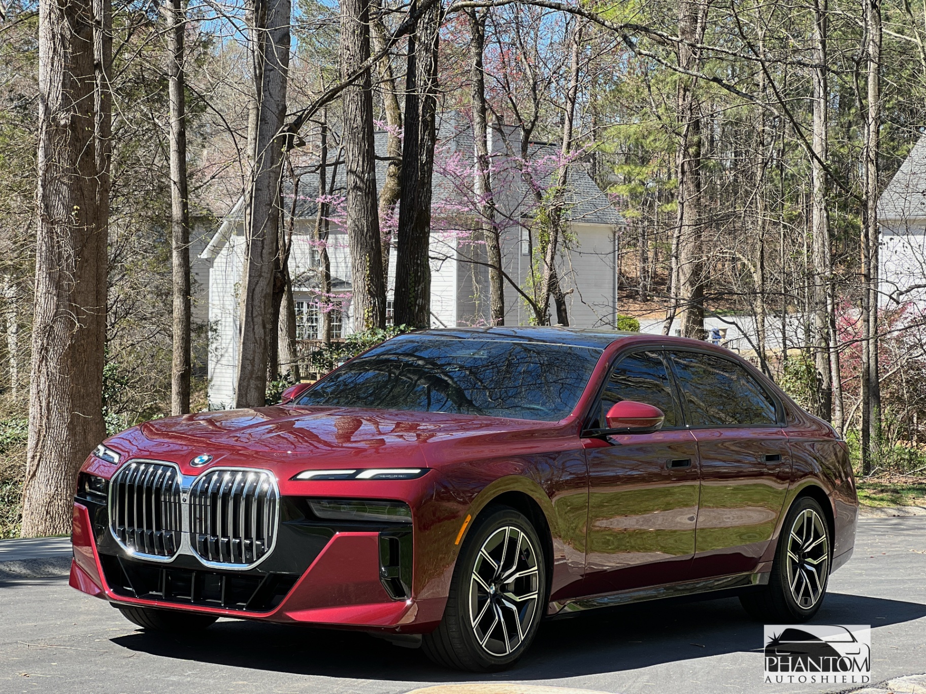 Red BMW 7 Series sedan with high-gloss finish parked outdoors.