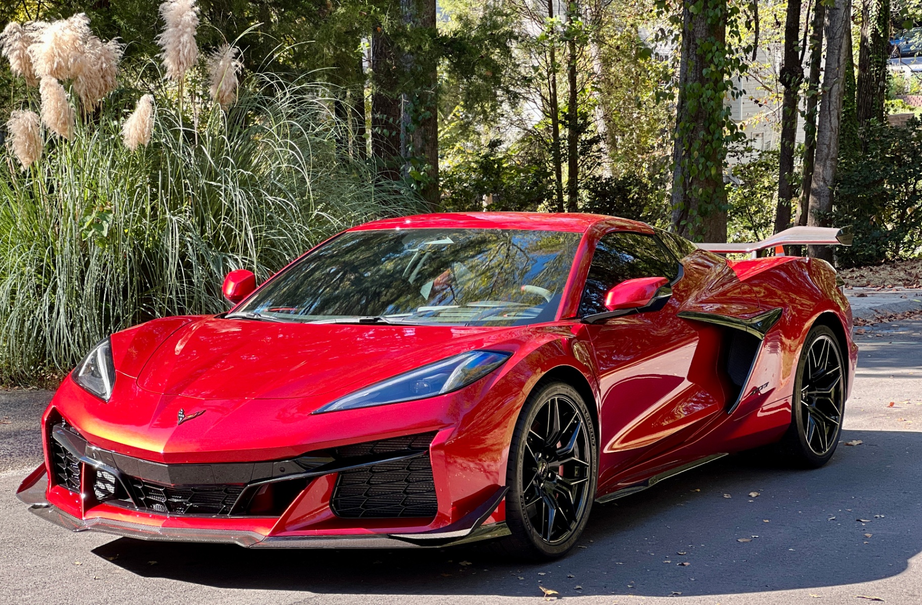Red Corvette C8 sports car with glossy paint finish and outdoor reflections.
